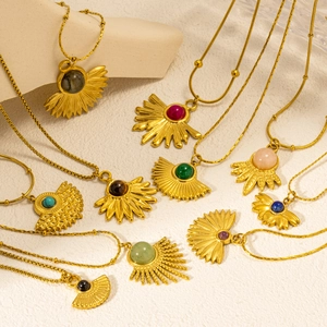 Détails de pendentifs bohèmes en or avec pierres semi-précieuses sur pierres crème