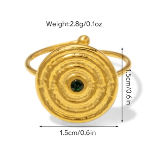 Détail de la bague dorée martelée avec pierre verte montrant la taille de 1,5 cm de large