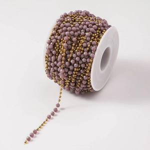 Dettaglio di perle di cristallo lavanda sfaccettate e perle di metallo dorato