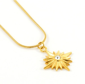 Détail du pendentif étoile dorée avec zircon sur une chaîne serpent élégante pour femme
