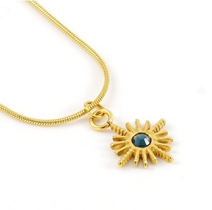 Détail du collier pendentif étoile dorée avec pierre bleue et chaîne serpent élégante