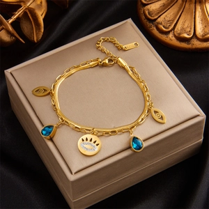 Detail eines mehrlagigen Goldarmbands aus Edelstahl mit blauen Evil Eye Anhängern