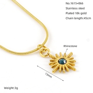 Detailed view of an 18k gold plated stainless steel sunburst necklace with blue rhinestone