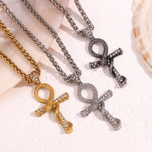 Macro detail of iced-out snake Ankh cross pendants with wheat chains in gold and silver