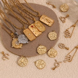 Close-up of gold tarot and zodiac pendants with embossed sun, star and cancer symbols