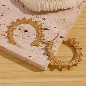 Detailed view of 18K gold plated wheat pattern texture on C-shape hoop earrings