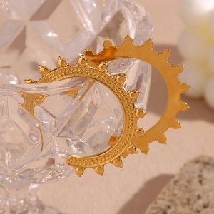 Macro detail of 18K gold-plated hoop earrings with intricate wheat grain patterns