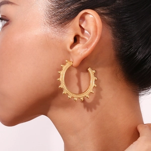 Bohemian gold-plated wheat grain hoop earrings with textured detail on female model