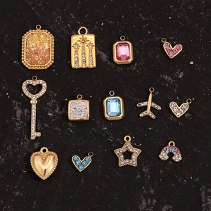 Detailweergave van diverse 18K vergulde mini hart- en sterbedeltjes met micro-kristallen
