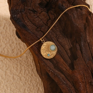 Close-up of vintage 18K gold plated celestial compass pendant with sun and star motifs