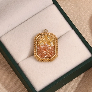 Macro-opname van 18K gouden hart hanger met geel en roze gradiënt van micro-pave kristallen