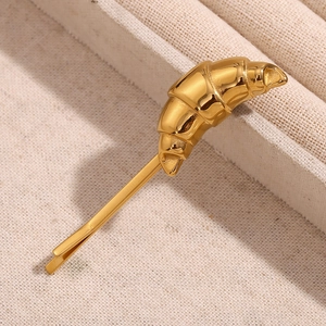 Macro shot of 18K gold plated stainless steel croissant hair clip on a jewelry box