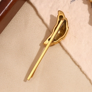 Macro view of a 18K gold plated stainless steel hair clip with a shell texture finish