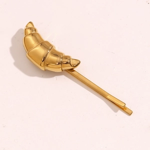 Detail shot of the vintage croissant-shaped hair clip in 18K gold plated stainless steel