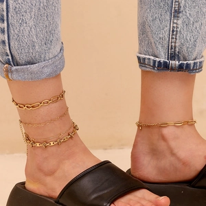 Detailed layered anklets with 14K gold heart charms and chunky links on ankle
