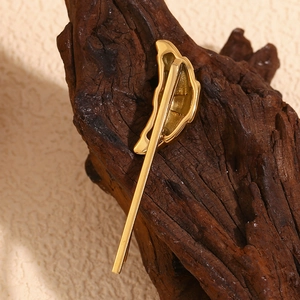 Retro horn shaped hair clip in 18K gold plated stainless steel on dark wood base