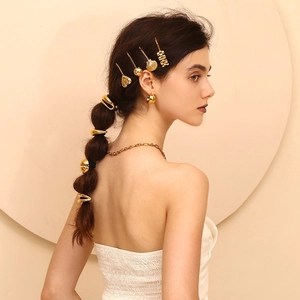 Detail eines 18K vergoldeten Mond-Haarrings und Clips in einer eleganten Flechtfrisur