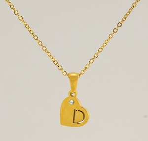 Détail du pendentif cœur doré avec la lettre D ajourée et une petite pierre de zircon
