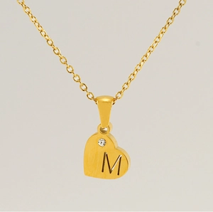 Détail du pendentif coeur avec lettre M et zircon sur chaîne en acier doré à l'or 18K