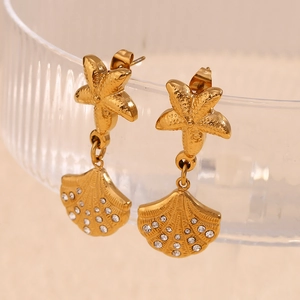 Detailed macro view of 18K gold star fish and seashell drop earrings with crystals