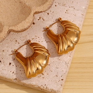 Detail of 18K gold-plated ribbed hoop earrings with high-polish finish on stone