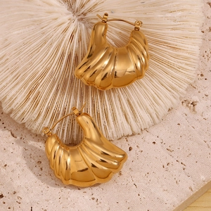 Detailed macro view of hollow wave pattern hoop earrings in 18K gold plated stainless steel