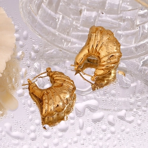 Macro detail of 18K gold plated hollow wing earrings with waterproof water droplets