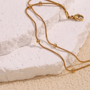 Detailed view of the double-layer 18K gold-plated snake chain anklet with round beads