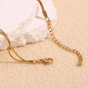 Detail of 18K gold plated double layer snake chain anklet with lobster clasp and drop pendant
