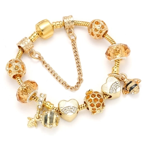 Detailed view of a gold-plated snake chain bracelet with bee and turtle charms
