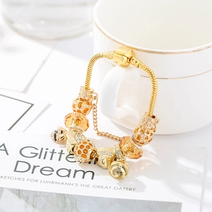 Close-up of golden honeybee charm bracelet with yellow crystals on a porcelain cup