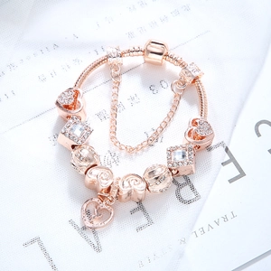 Bracelet à breloques en or rose avec pendentifs cœur et perles en cristal sur maille serpent