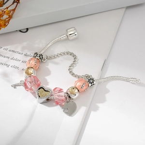 Rosa DIY-Charm-Armband mit Herz-Schlüssel-Anhänger auf silberner Schlangenkette und Glasperlen