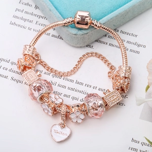 Eleganter roségoldener Schlangen-Charm-Armband mit Herzanhänger und floralen Perlen
