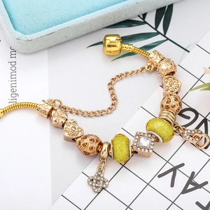 Goldenes Schlangenarmband mit Herzanhängern, Kristallperlen und grünen Details