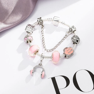 Pink charm bracelet with silver snake chain, pink glass beads and music headset pendant