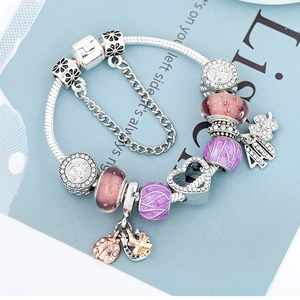 Silver snake chain bracelet featuring pink and purple glass beads and heart charm