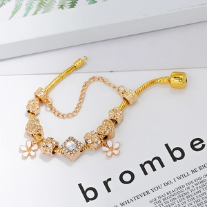 Gouden bedelarmband met slangenschakel, hart- en bloemkralen en een zirkonia hanger