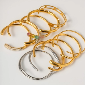 Detail of 18K gold-plated cuff bracelets featuring pearls and colorful rhinestones