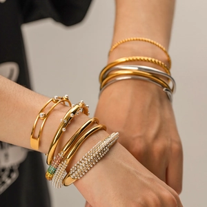 Stacked 18K gold and silver plated titanium bracelets with pearls and sparkling diamonds