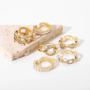 Set of luxury gold-plated rings with zircon inlays on natural stone background