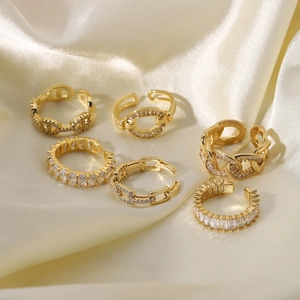Set of six gold-plated adjustable rings with zircons on elegant champagne silk background