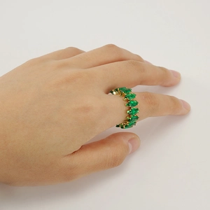 Detail of gold adjustable ring with marquise-cut green gemstones on model hand
