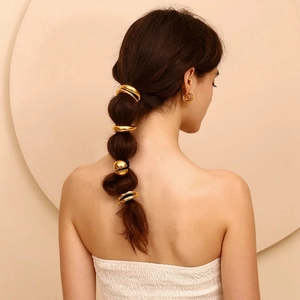 Polished 18K gold moon-shaped hair tie shown on bubble ponytail for elegant styling