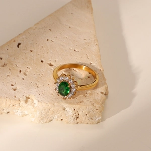 Detailed close-up of 18K gold stainless steel ring with green oval zircon and halo diamonds