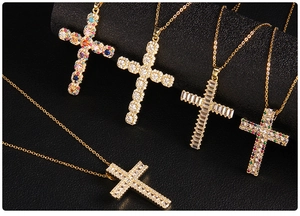 Detailed view of various gold-plated cross pendants with micro-inlaid colorful zircons