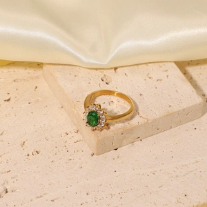 Detailed view of 18K gold stainless steel ring with oval green zircon and halo stones