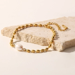 Détail du bracelet perle baroque d'eau douce avec perles dorées sur pierre texturée