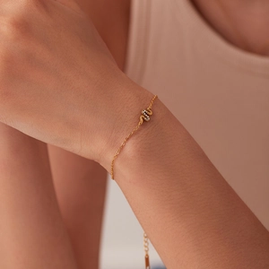 Dettaglio di un bracciale a serpente placcato oro 18K con zirconi indossato al polso