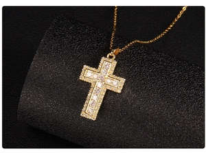 Macro shot of gold-plated cross pendant with micro-pave cubic zirconia on black stand